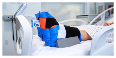Patient wearing heel protector boots to prevent pressure injuries on a ProCuity bed