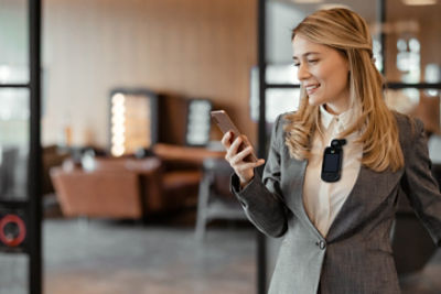 Hotel manager wearing Vocera Smartbadge in hotel lobby