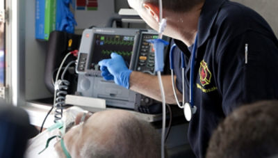 Professionnel des soins médicaux d'urgence montrant le moniteur/défibrillateur LIFEPAK 15 à l'arrière d'une ambulance