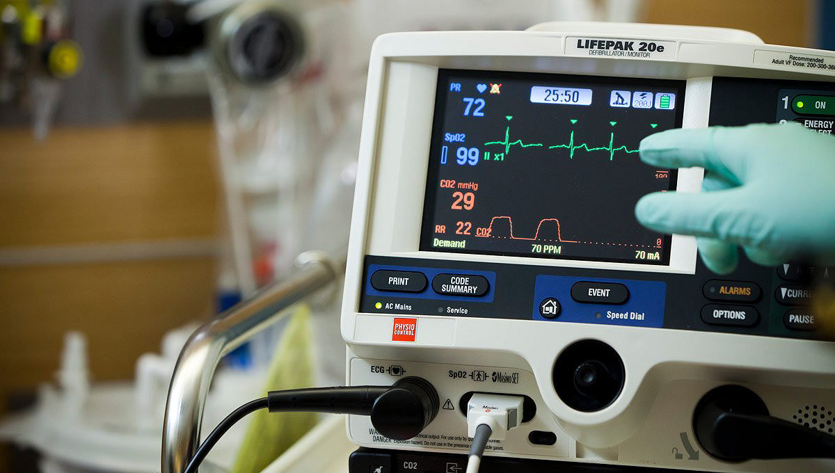 Prim-plan cu un profesionist din domeniul medical care indică ecranul unui monitor-defibrilator LIFEPAK 20e