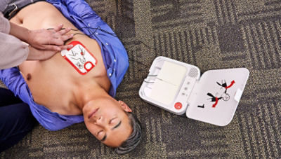 Bystander performs chest compressions on a sudden cardiac arrest victim with an AED. 