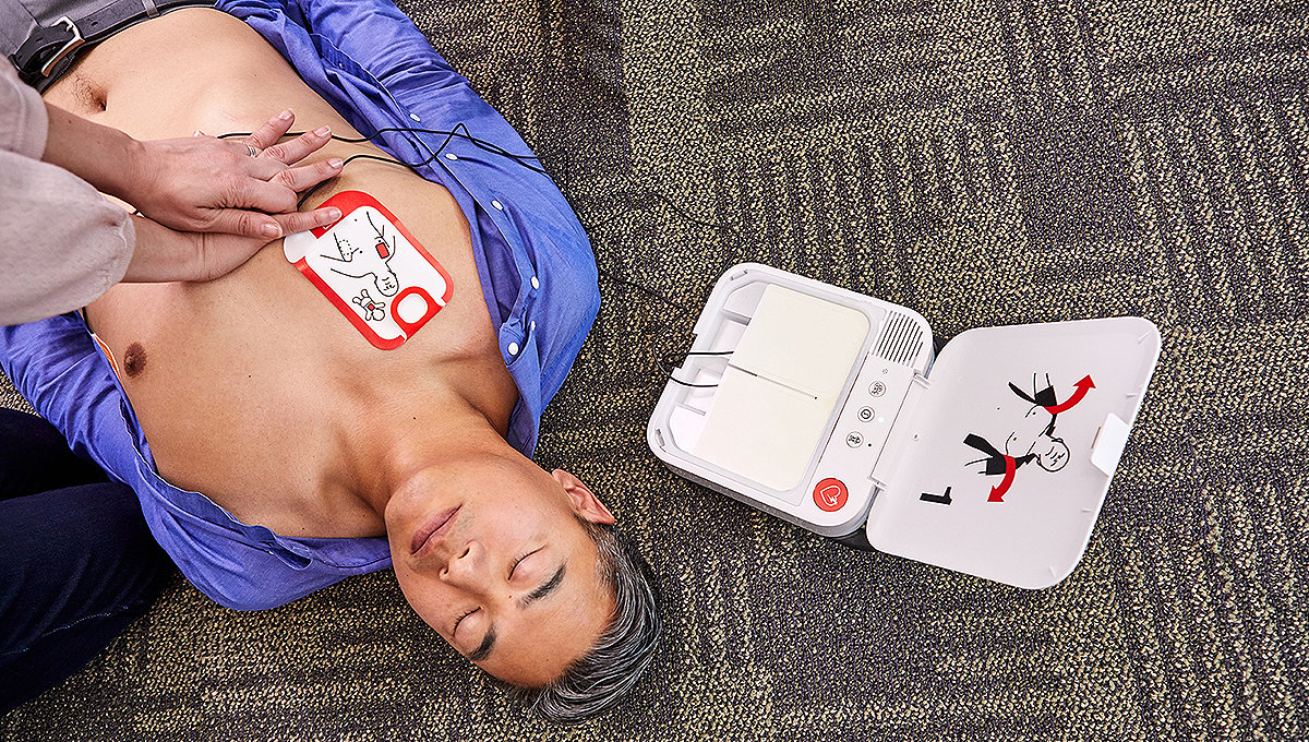 Bystander performs chest compressions on a sudden cardiac arrest victim while a LIFEPAK CR2 defibrillator is onnected to the victim. 