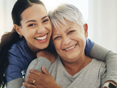 Nurse hugging patient both smiling