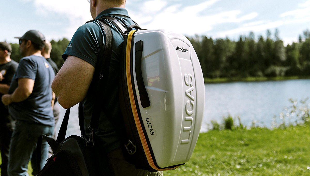 An EMT carries the LUCAS 3, v3.1 device on his back using the carrying case. 