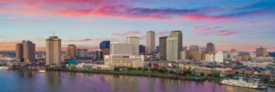 New Orleans skyline under a pink and blue sunset