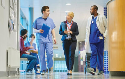 hospital staff walk down hallway