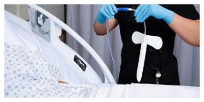 Nurse holding PrimaFit External Urine Management next to a patient in a ProCuity bed