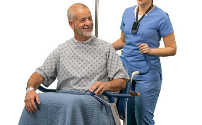 A nurses uses the BackSmart push handles on the Prime TC hospital transport wheelchair