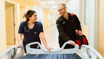 Nurse and ProCare services technician pushing hospital bed