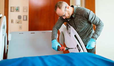 ProCare tech servicing hospital bed