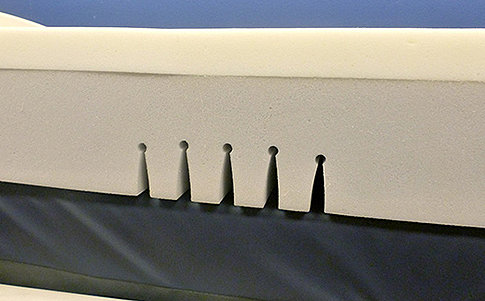 Hospital mattress includes articulation cuts for head of bed elevation