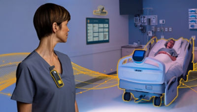 Nurse wearing Sync Badge looking back at patient in ProCuity bed