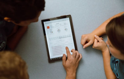 Three medical professionals review patient data on a tablet using CODE-STAT data review software 