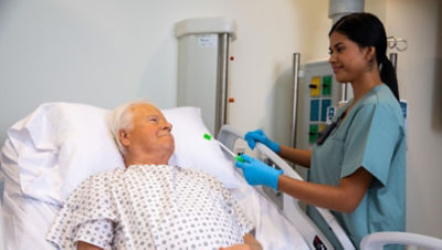 Nurse using non-ventilated oral care product on a patient in a ProCuity bed