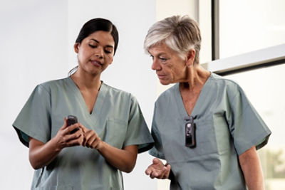 two nurses using Sync badges to collaborate