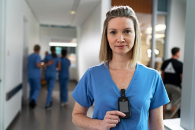 nurse holding communication device clasped to shirt